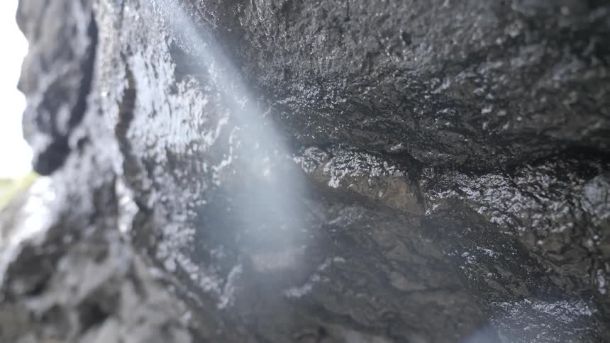Water droplets dripping off a rock