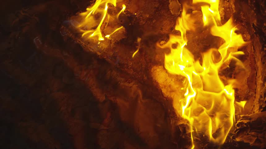 The fire is burning in the dark stove