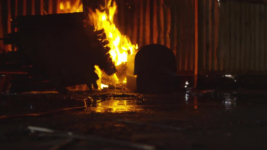A television is hit with a hammer into the fire