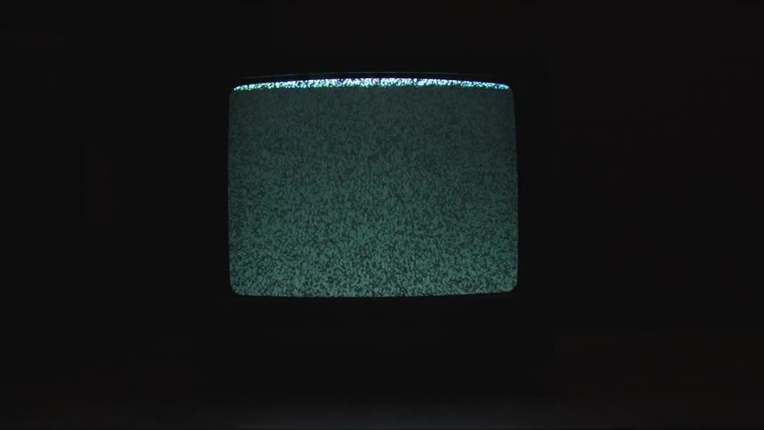 A television playing static in a dark room