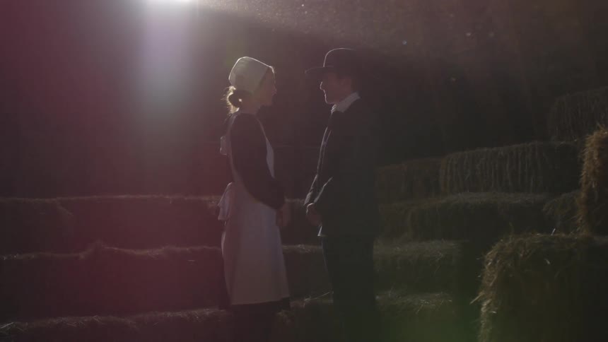 A man and woman staring at each other in a barn