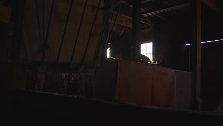 The sun shines through the windows of a dark room