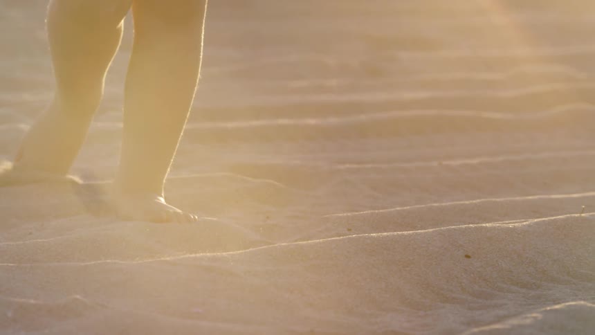 A young boy plays in the sand on a sunny day