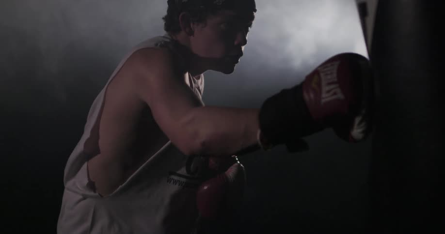 Man punches a heavy bag in a gym