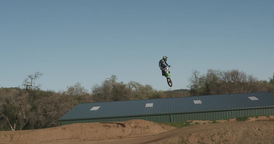 Person riding dirt bike does a trick off a ramp