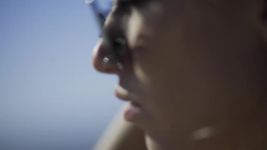 Woman adjusts her hair on a sunny day
