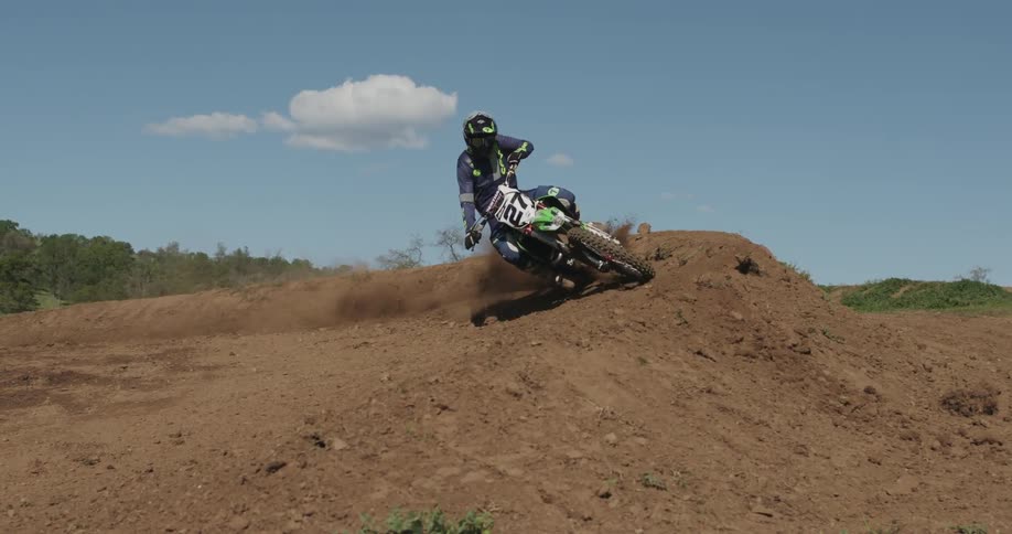 A man rides his dirt bike through a dirt course