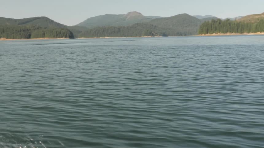 Man Driving Boat Around Lake