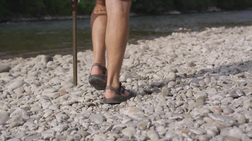A man is walking along the shoreline