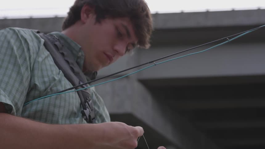 A man wrapping a piece of fishing line around his finger