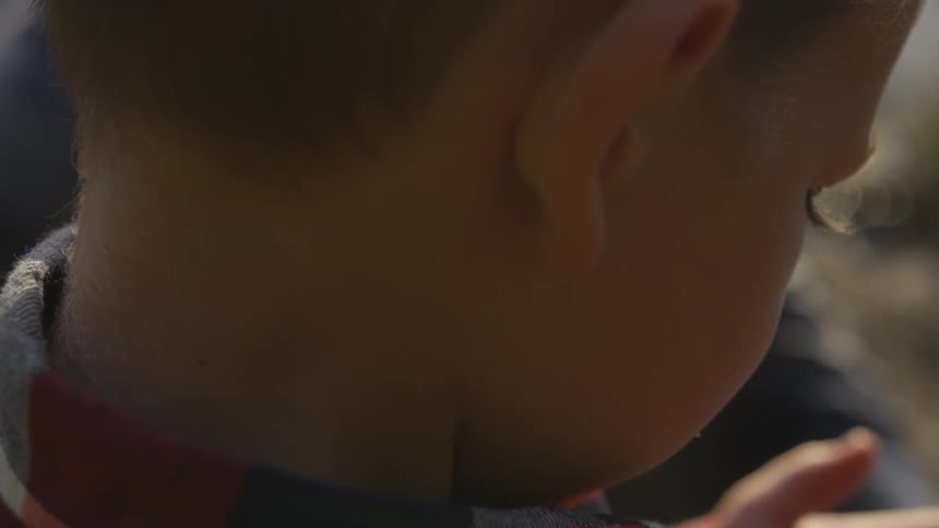 Child looks down at hands