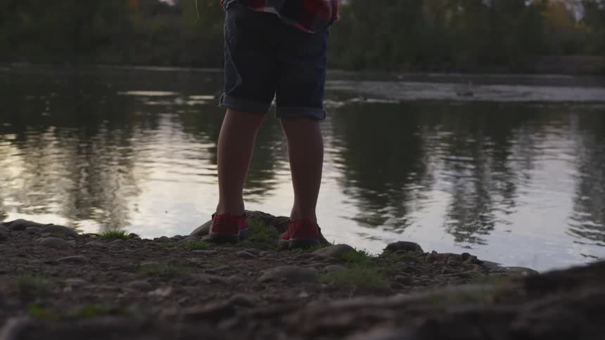 Person stands on bank fishing