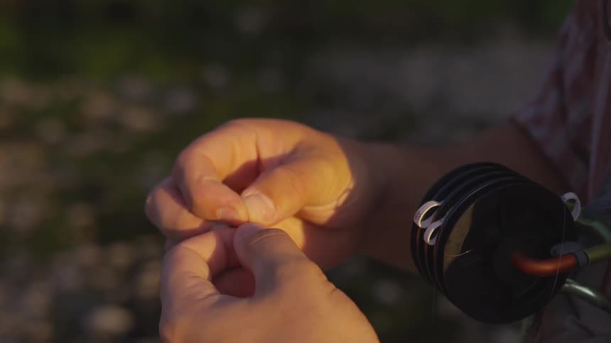 Man tries to set up fishing rod at sunset