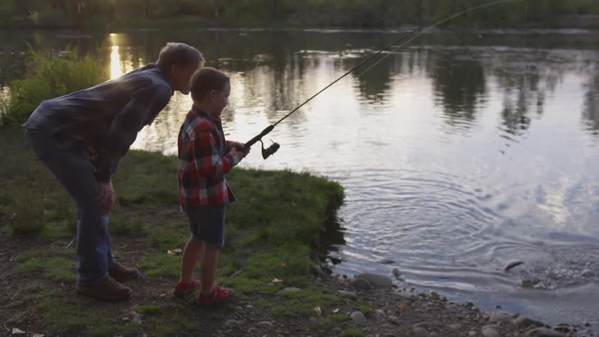 Man and boy fishing along a river