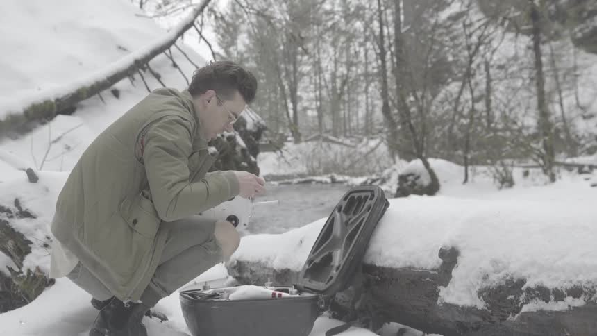 A man puts together his drone in the snow