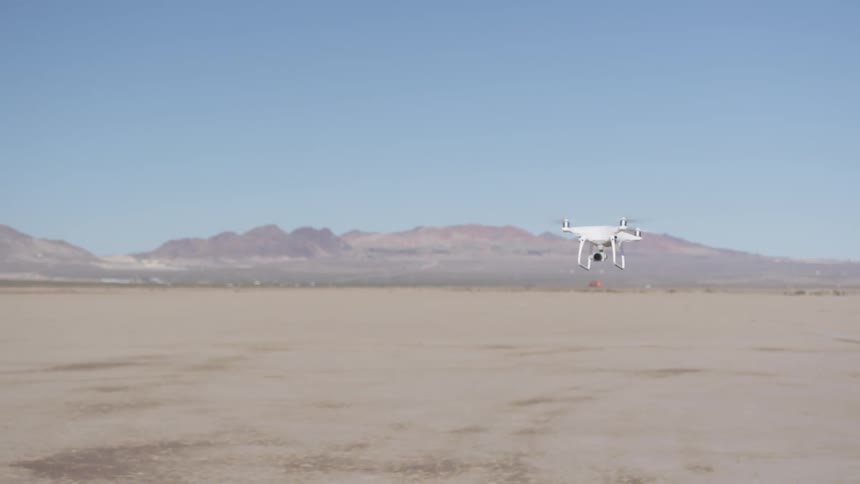 A drone flies over a desert