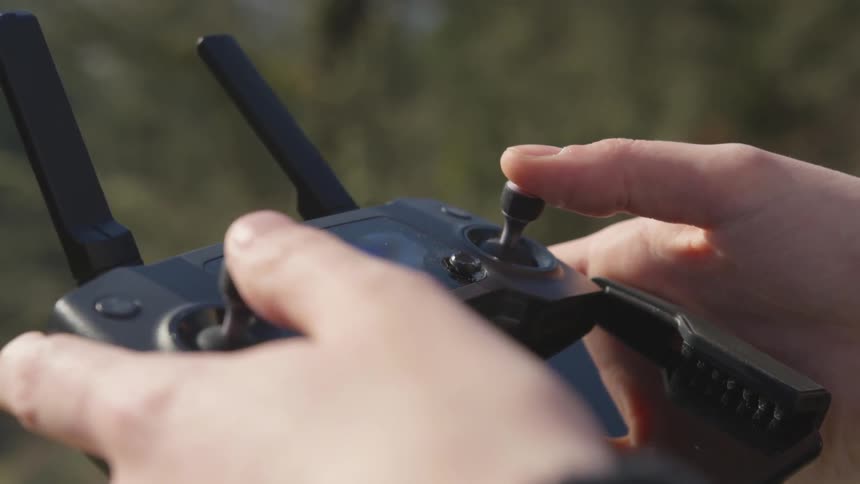 Two white hands moving levers back and forth on a rc controller