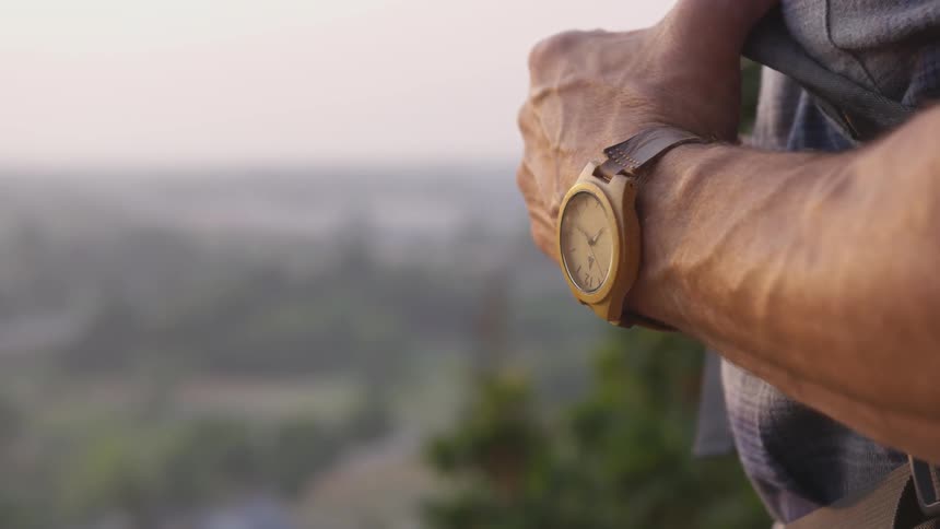 A close up of a man wearing a watch outdoors