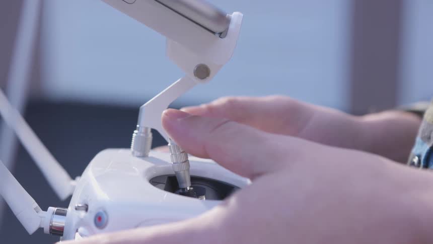 Person manipulates white drone controller