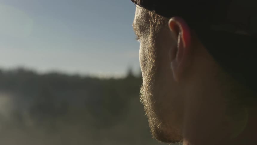Man looks out at water while standing on shore
