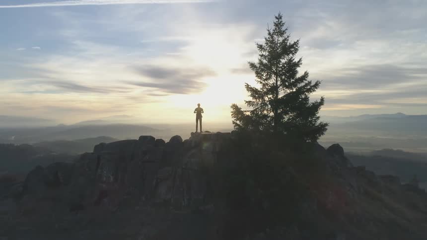 Zooming out on a person standing on top of a hill