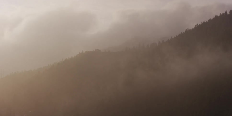 Smoke hanging heavy over a mountainside