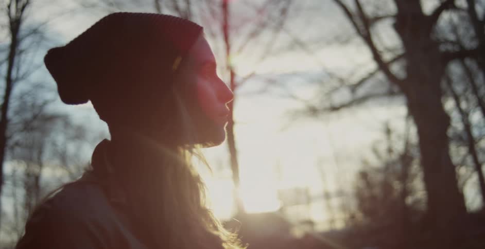 Woman standing outside looking around at sunset