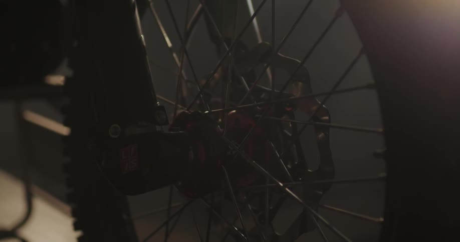 Close up of a motorcycle wheel spokes in a dark room