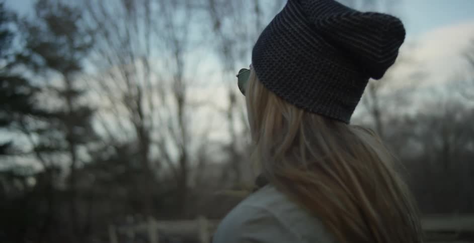 A woman stands on a ranch on a fall morning