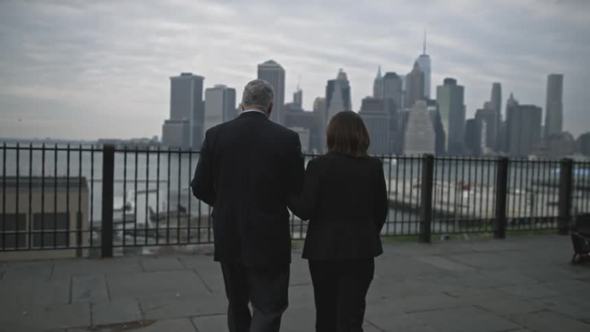 A man and woman walking with their arms linked in a city
