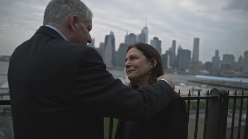 A man strokes a woman's hair on a cloudy day