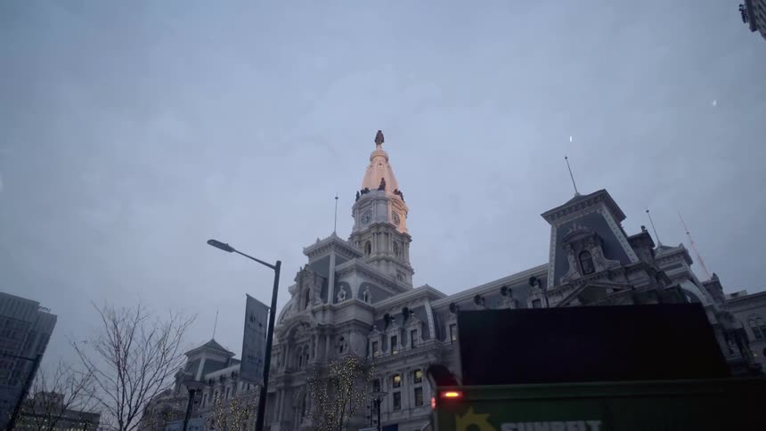 A large historic city building looms against clouds