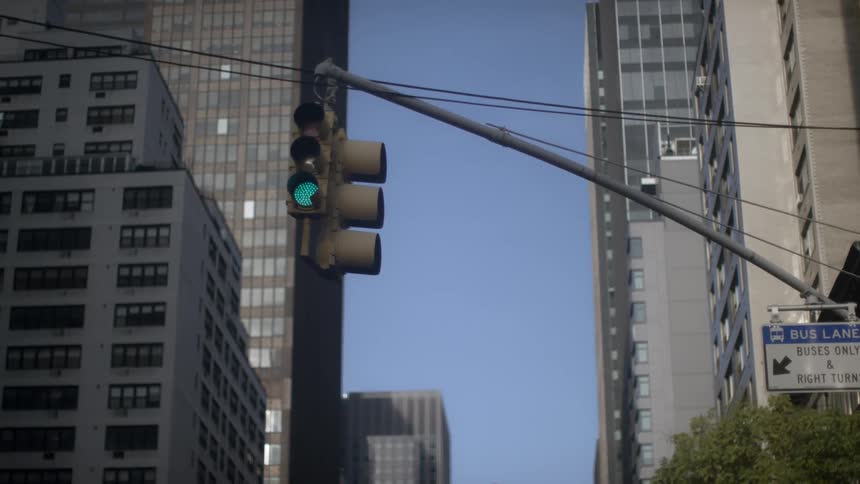 Overhead traffic light between tall buildings