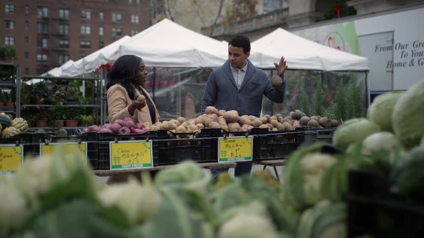 A couple shop for produce at a city market