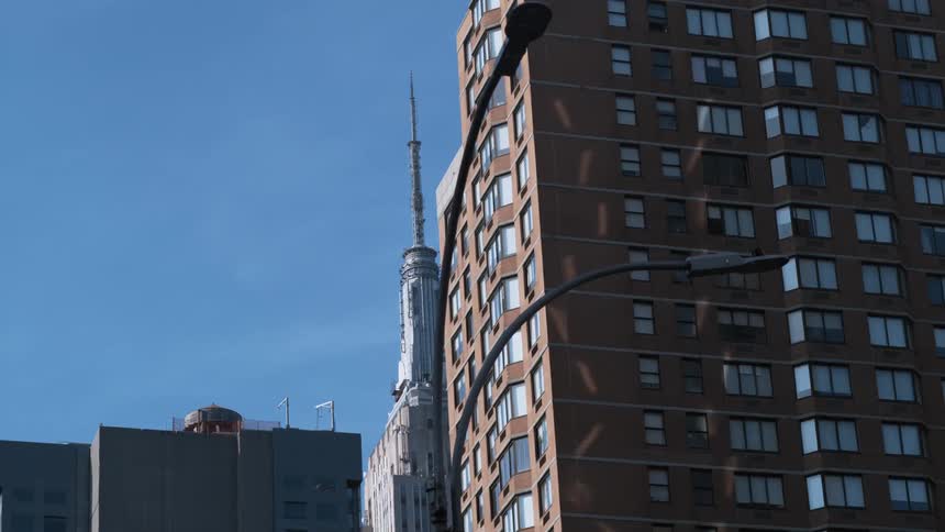Street lights and city buildings against a blue sky