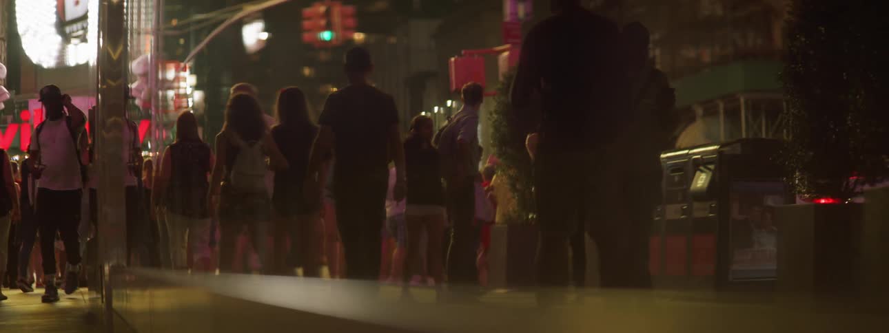 People walking at night with street and sign lights
