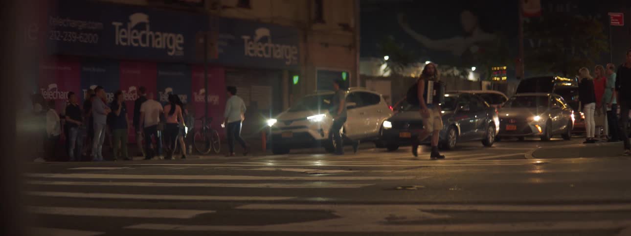 Crosswalk with people walking and cars waiting