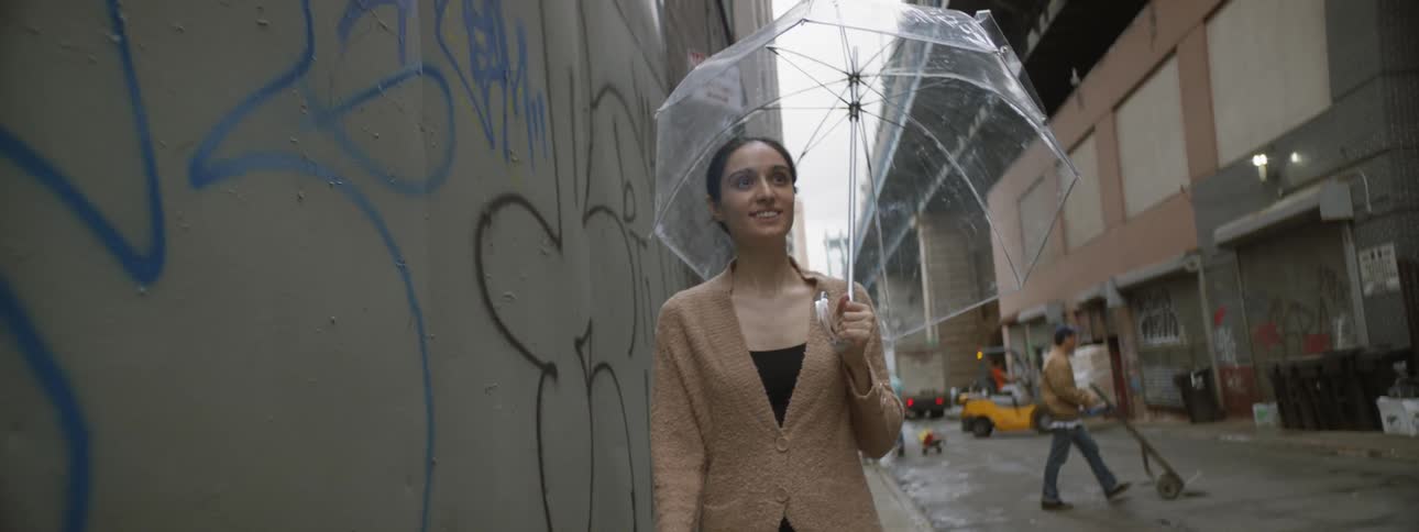 Woman walking next to graffiti wall