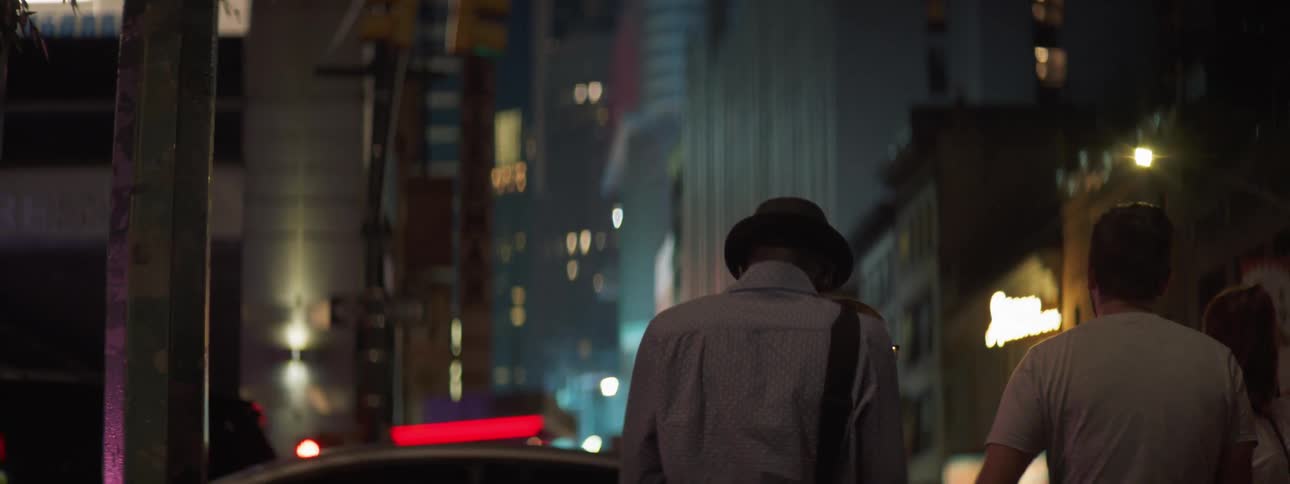 Person in hat waiting while cars drive by