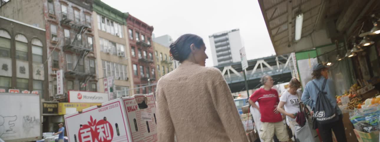 Woman with brown hair looking at street market