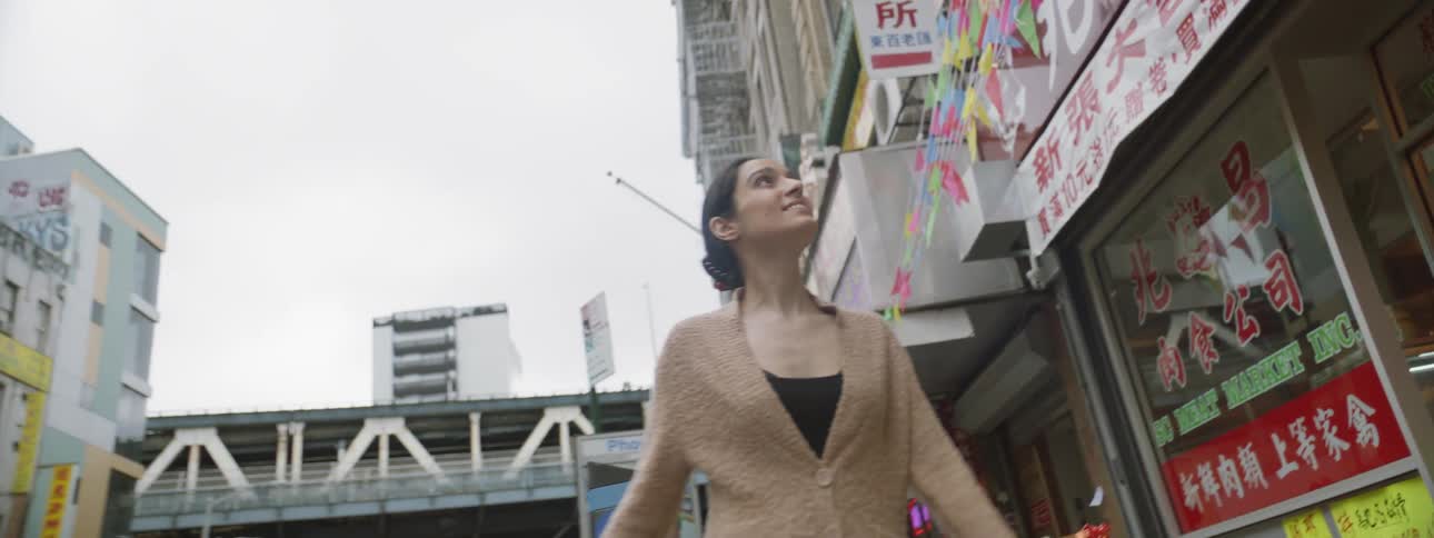 Smiling woman looking at signs on street