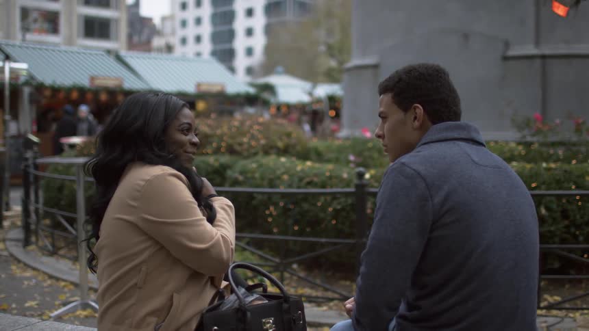 A man and a woman sitting in a park having a conversation