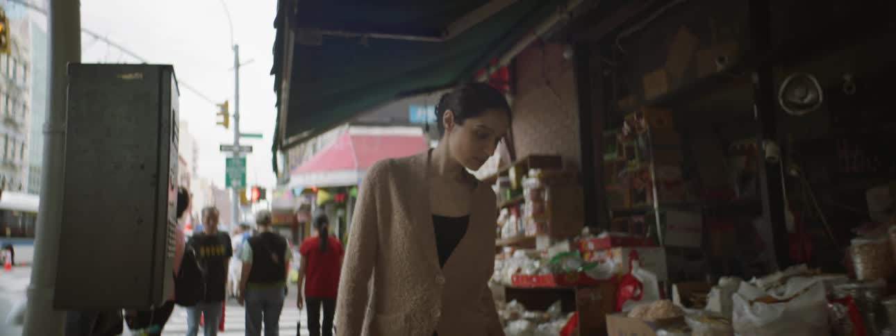 Young woman walking down street looking a store market