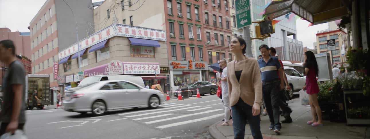 Woman looking around chinatown while crossing the street
