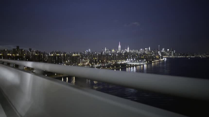 First person view of driving across a bridge over water in an urban area