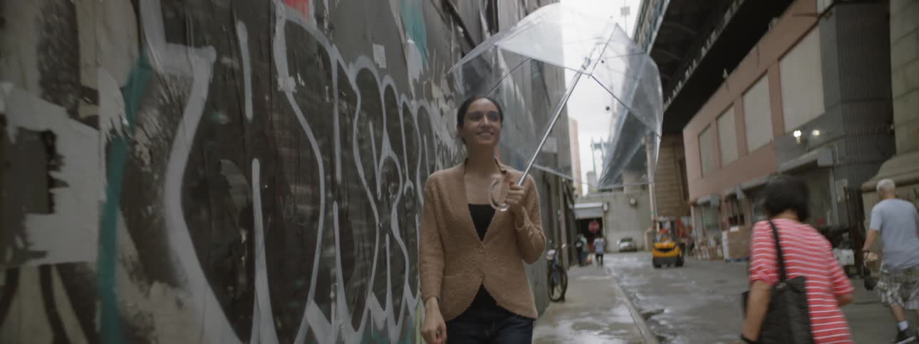 Woman walking down street with umbrella