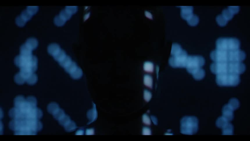 Lights in several patterns reflect off a woman's face
