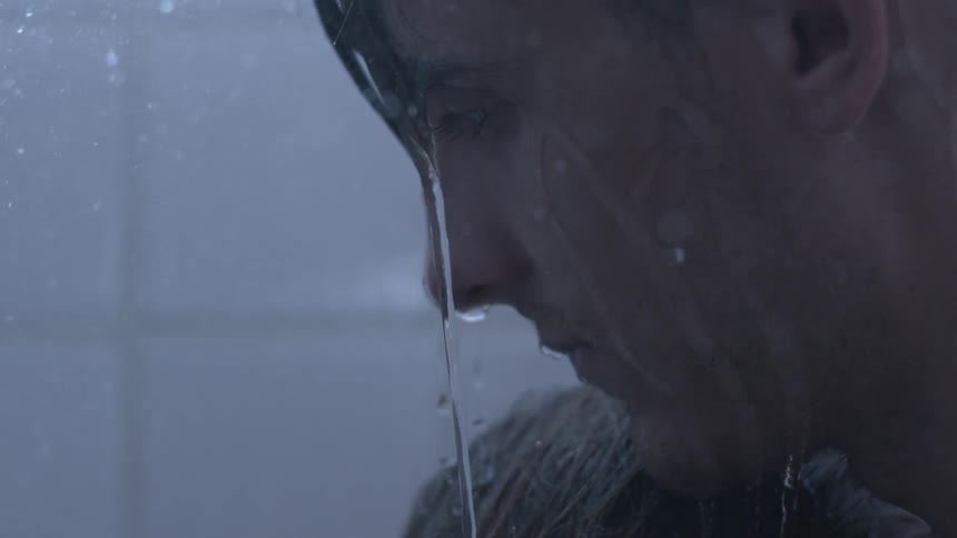 Water dripping from a man's face in the shower