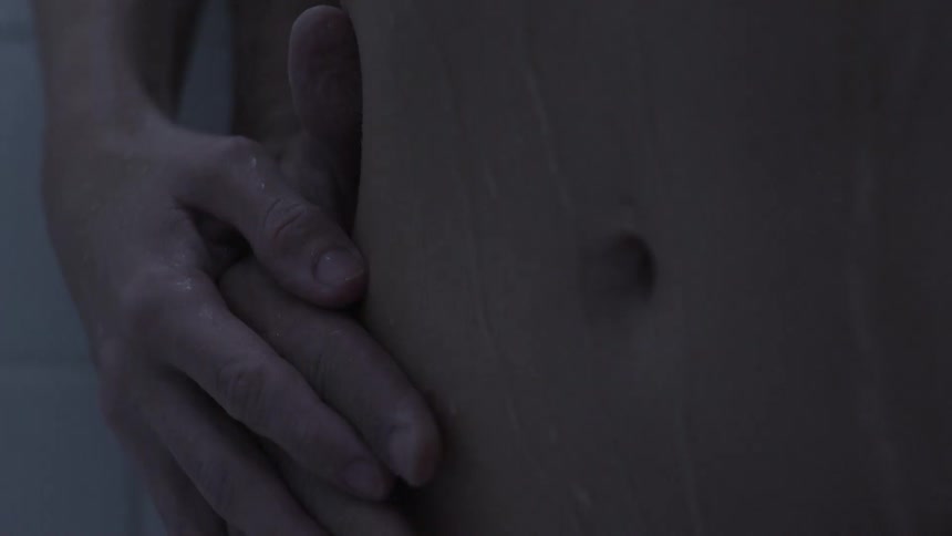 Man and woman embrace while showering