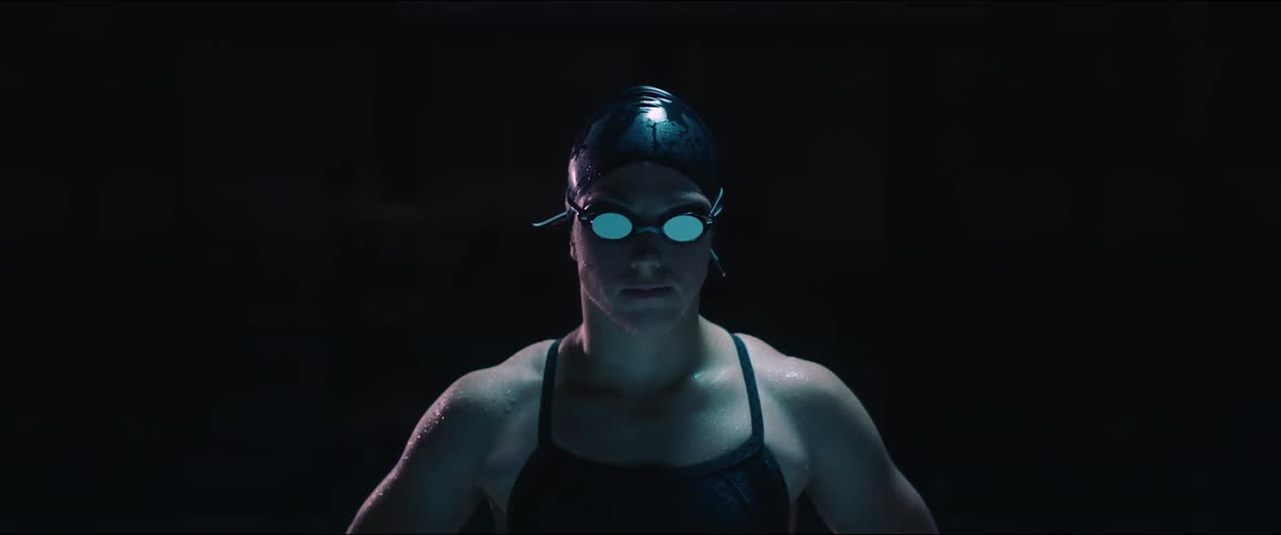 A woman wearing a swimming cap and goggles